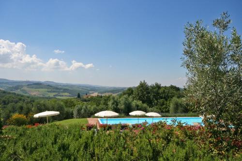 a swimming pool with umbrellas on top of a hill at Podere Il Pino in Poggibonsi