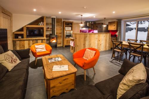 ein Wohnzimmer mit einem Sofa, Stühlen und einem Tisch in der Unterkunft Chalet Atelier Chalet Chamonix in Chamonix-Mont-Blanc