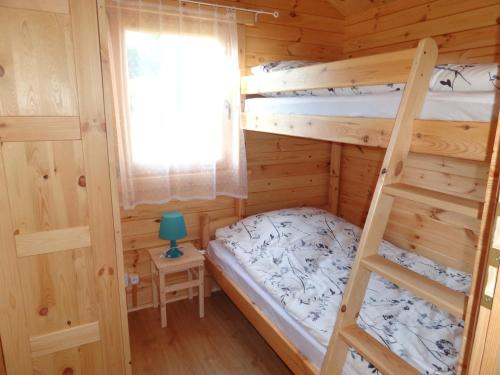 a bedroom with two bunk beds and a ladder at Anielsko domki nad morzem in Mielenko