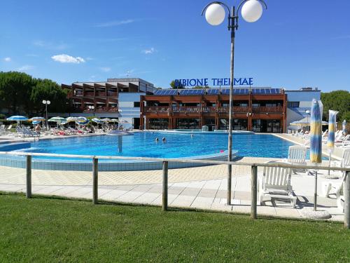 a large swimming pool in front of a building at Condominio Moschettieri trilocale in Bibione