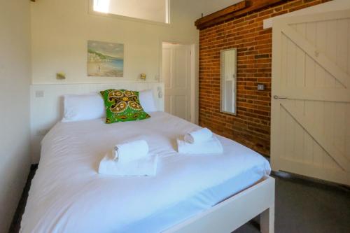 two twin beds in a room with a door at The Dairy Cottage in Aldeburgh