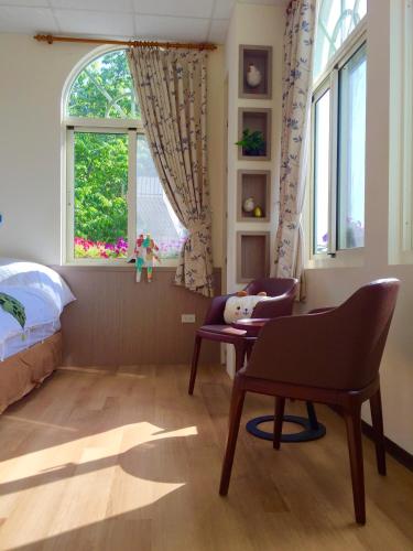 a bedroom with a bed and a chair and a window at David's House in Fanlu
