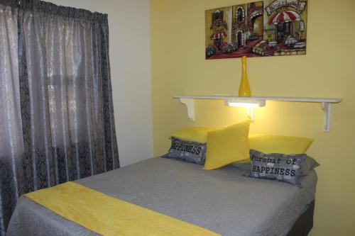 1 dormitorio con 1 cama con un estante en la pared en PhysEQFiT Guesthouse & Spa, en Centurion