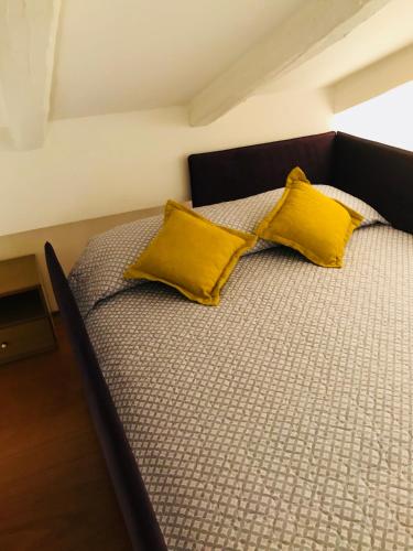 a large bed with two yellow pillows on it at Carina Loft in Venice