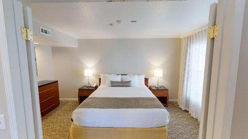 a bedroom with a large bed with two night stands and two lamps at Chase Suite Hotel Newark Fremont in Newark