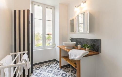 La salle de bains est pourvue d'un lavabo et d'un comptoir avec évier. dans l'établissement le jardin de Camille, à Tailleville