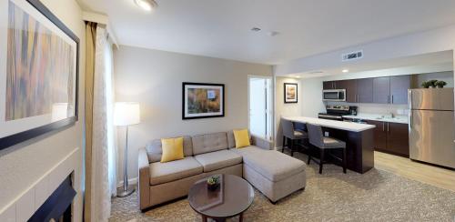 a living room with a couch and a kitchen at Chase Suite Hotel Newark Fremont in Newark