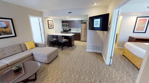 a living room with a couch and a bed and a kitchen at Chase Suite Hotel Newark Fremont in Newark