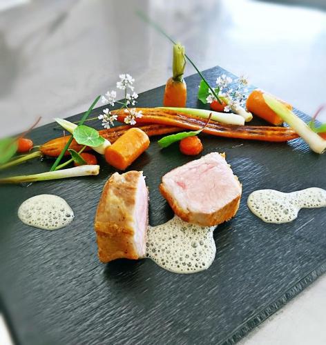 a plate of food with meat and vegetables on it at BRUGGER'S Hotelpark am See in Titisee-Neustadt