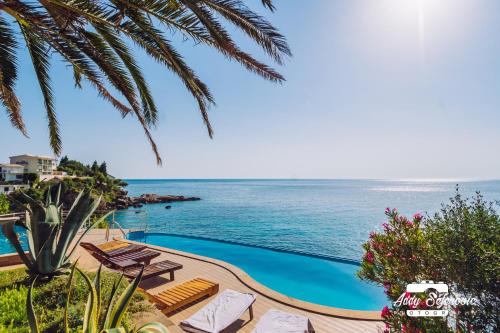 a swimming pool with a view of the ocean at Resort Stikovic in Dobra Voda