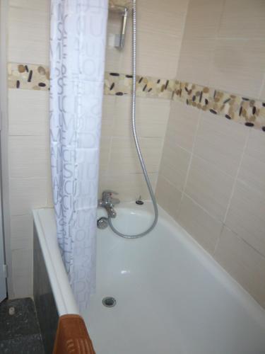 La salle de bains est pourvue d'une douche et d'une baignoire blanche. dans l'établissement Studio Centre Ville Office De Tourisme, à Bayonne