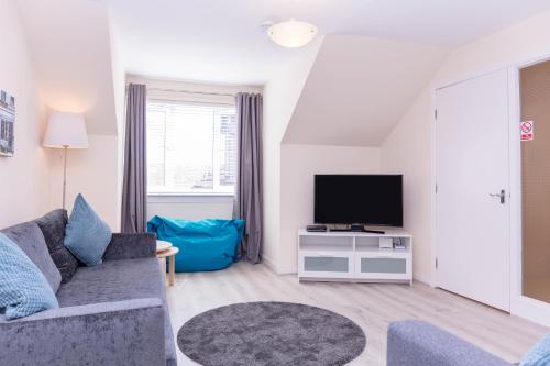 a living room with a couch and a tv at Ailsa Retreat in Troon