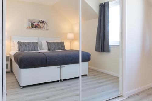 a bedroom with a bed and a mirror at Ailsa Retreat in Troon