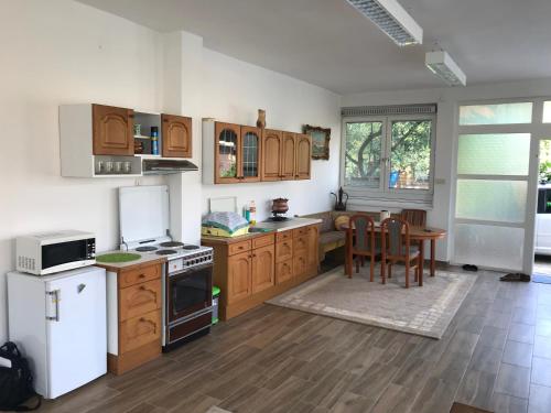 eine Küche mit Holzschränken und einem Tisch mit Stühlen in der Unterkunft Villa K&K in Sarajevo