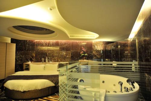 فندق اكسبيرينس في جونية: غرفة في الفندق مع سرير وحوض استحمام