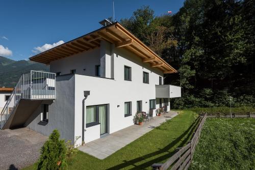 a white house with a balcony and a yard at Ferienwohnung Unterlechner in Vomp