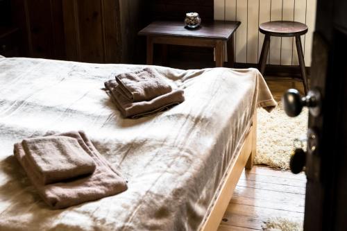 a bed with two towels on it with a table at Banskovilla Zlateva House in Bansko