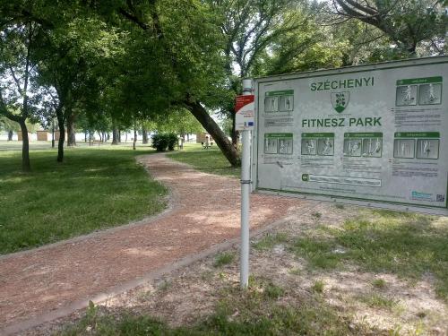 a sign in a park next to a field at Sorompó Vendégház in Balatonkenese