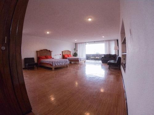 a large living room with a bed and a couch at Suites Las Plazas in Cuernavaca