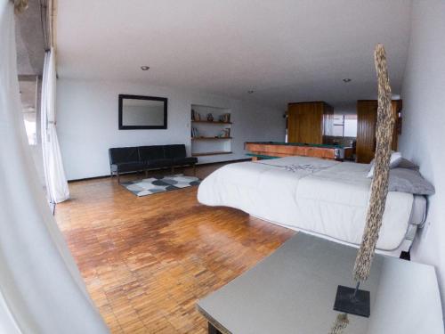 a bedroom with a swinging bed and a couch at Suites Las Plazas in Cuernavaca