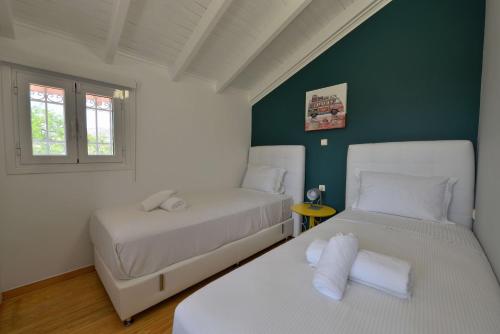 two beds in a room with green walls at Villa PortoMare in Porto Rafti