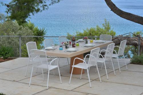 a table and chairs on a patio overlooking the ocean at Villa PortoMare in Porto Rafti