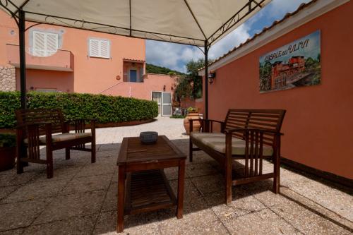 a patio with chairs and a table and a building at Casale Gli Ulivi in Orbetello