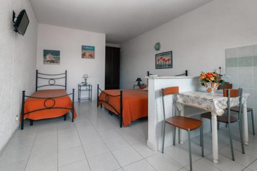 a bedroom with a bed and a table and chairs at Casale Gli Ulivi in Orbetello