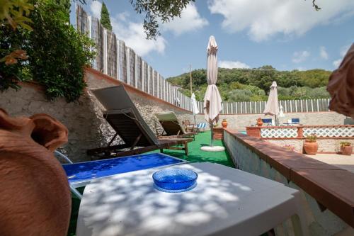 a table with a blue bowl on it on a patio at Casale Gli Ulivi in Orbetello