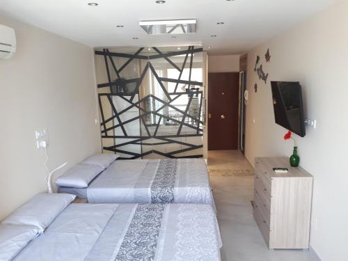 カルプにあるCalpe Centro Turisicoのベッドルーム1室(ベッド2台、薄型テレビ付)