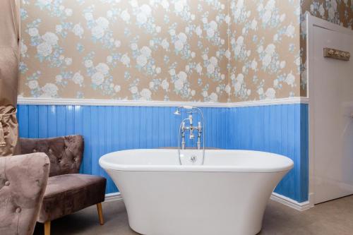 a bath tub in a bathroom with blue walls at Lunan House in Arbroath