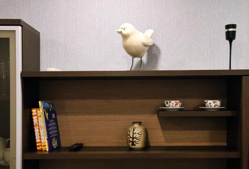 a white bird sitting on top of a book shelf at Relax Inn Druskininkai in Druskininkai