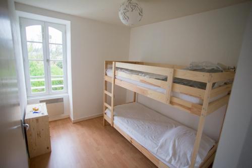 a bedroom with two bunk beds and a window at Gites du four saint Pierre in Angrie