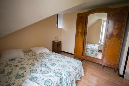a bedroom with a bed and a large mirror at Gites du four saint Pierre in Angrie