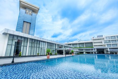 a swimming pool in front of a building at Becamex Hotel New City in Thu Dau Mot