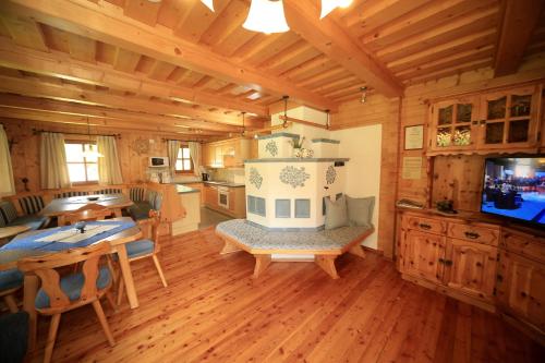 una sala da pranzo e una cucina in una baita di tronchi di Gasserhütte a Innerkrems