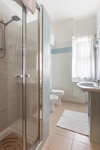 a bathroom with a shower and a toilet and a sink at Rodia Inn in Oristano