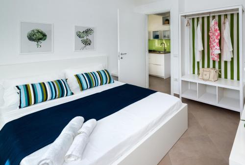 a white bedroom with a large white bed with pillows at Gi HOME Apartment vicino alla stazione e al Mare in Meta