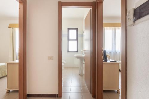 a bathroom with a toilet and a sink in a room at Rodia Inn in Oristano