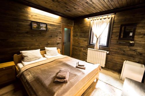 a bedroom with a large bed in a wooden room at Banskovilla Zlateva House in Bansko