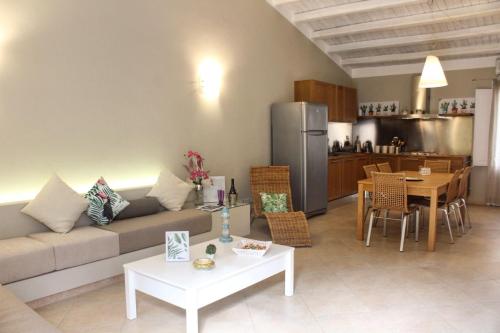 a living room with a couch and a table and a kitchen at Exclusive Marina Apartment in Castellammare del Golfo