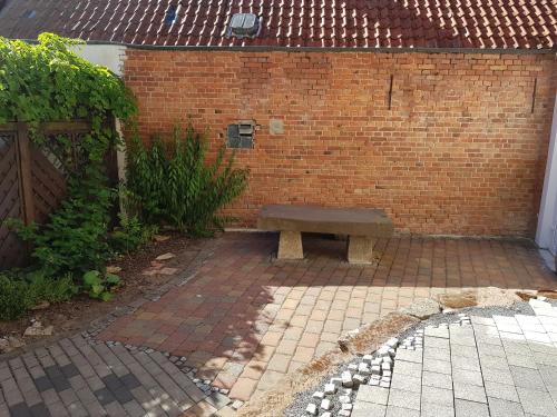a bench sitting in front of a brick wall at Monteurs-Ferienwohnung in Wolfhagen