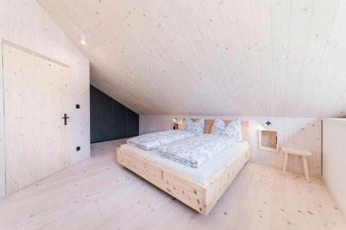 a bedroom with a bed in a white room at Obersteinerhof in Collalbo