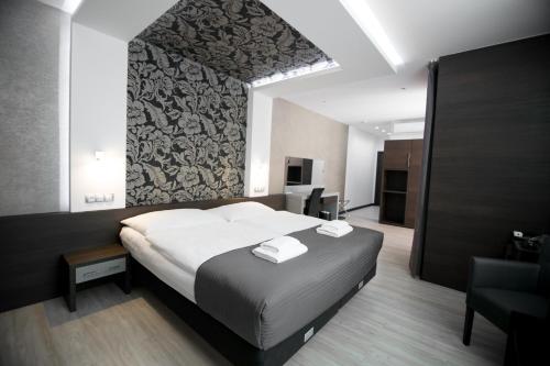 1 dormitorio con 1 cama con 2 toallas en Hotel U Kostela, en Modřice