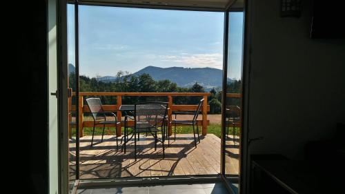 a balcony with a table and chairs on a deck at Chata na sjezdovce in Malenovice