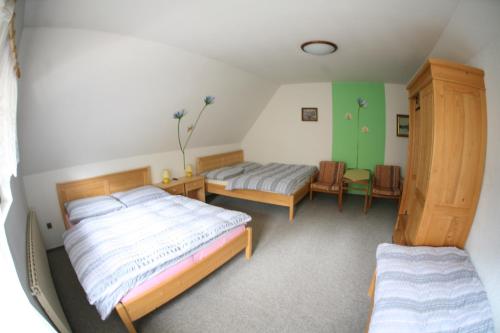 a bedroom with two beds and a table and chairs at Chalupa U Mateje in Trutnov