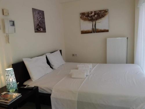 a bedroom with a large white bed with a night stand at Functional Studio in Sepolia Athens in Athens