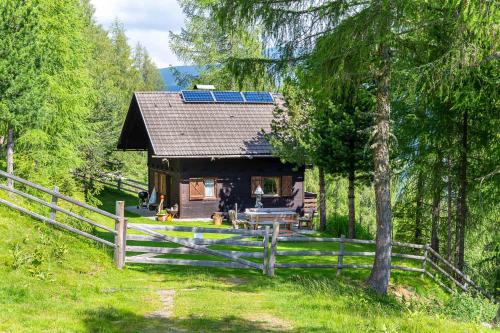 a house with a solar roof with a fence at Neuwirth Hütte in Gnesau