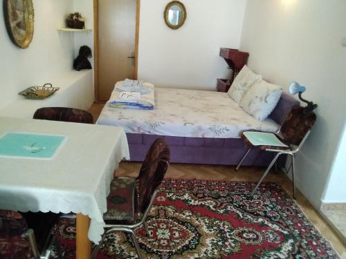 Schlafzimmer mit einem Bett, einem Tisch und Stühlen in der Unterkunft Apartments Obradović Milan in Žabljak