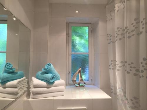 a bathroom with towels and a window and a pair of slippers at Ferienwohnung West in Stuttgart